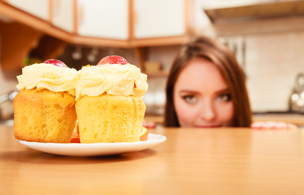 girl looking longingly at cupcakes