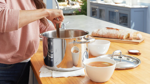 Bone Browth and a woman stirring a pot in the kitchen