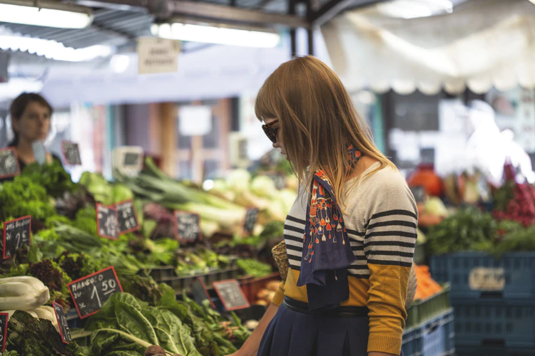 A woman looks through a produce market