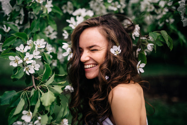 Girl smiling next to flowers