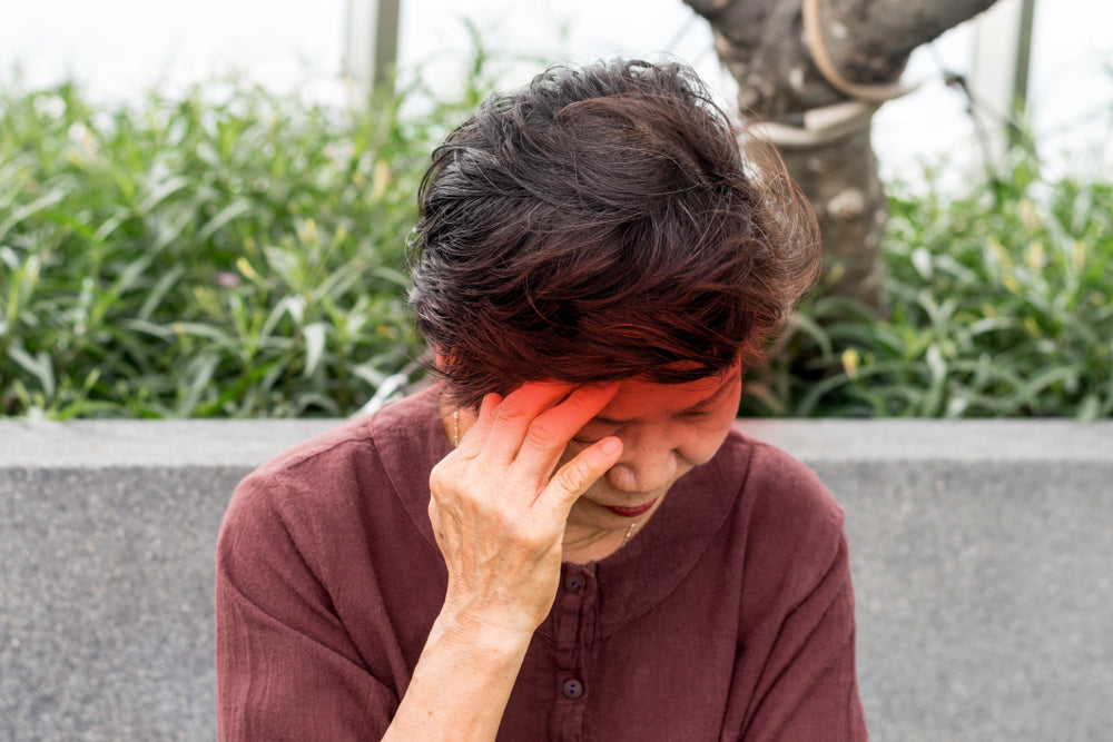 person holding their head with pain