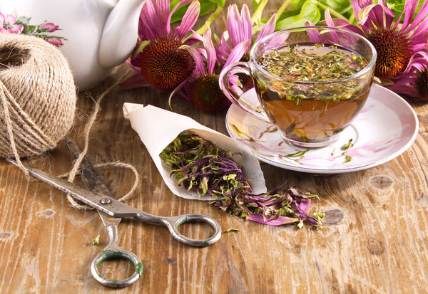 Satchel of antiviral herbs next to a cup of echidna tea