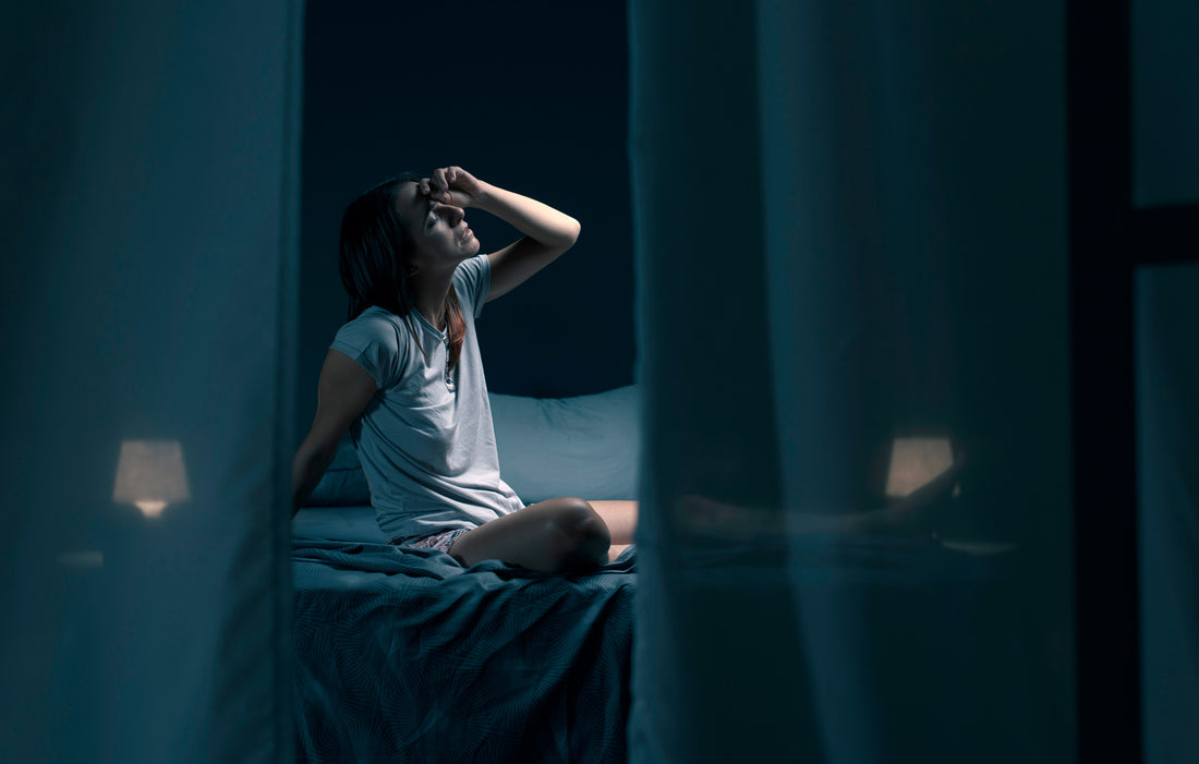 man holding his head at night 