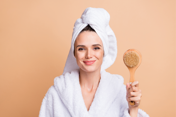 woman holding a dry brush in white towels