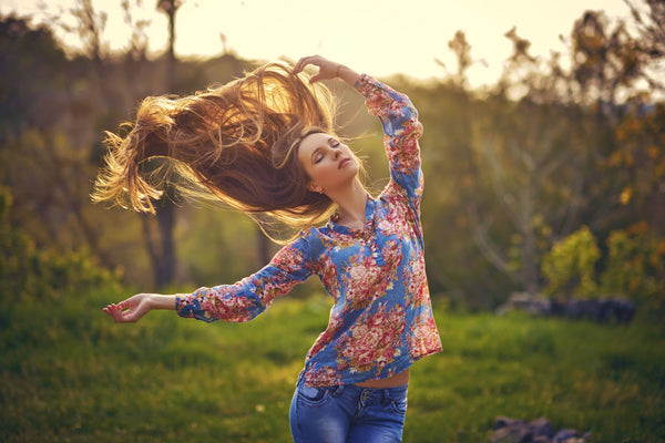 Girl with long brown hair dancing in the sunset