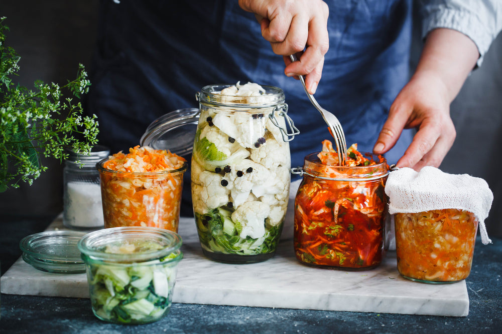 person canning various vegetables in jars