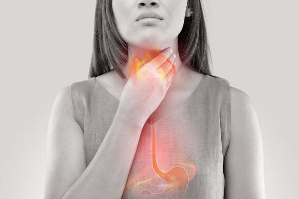 woman clutching her throat with acid reflux